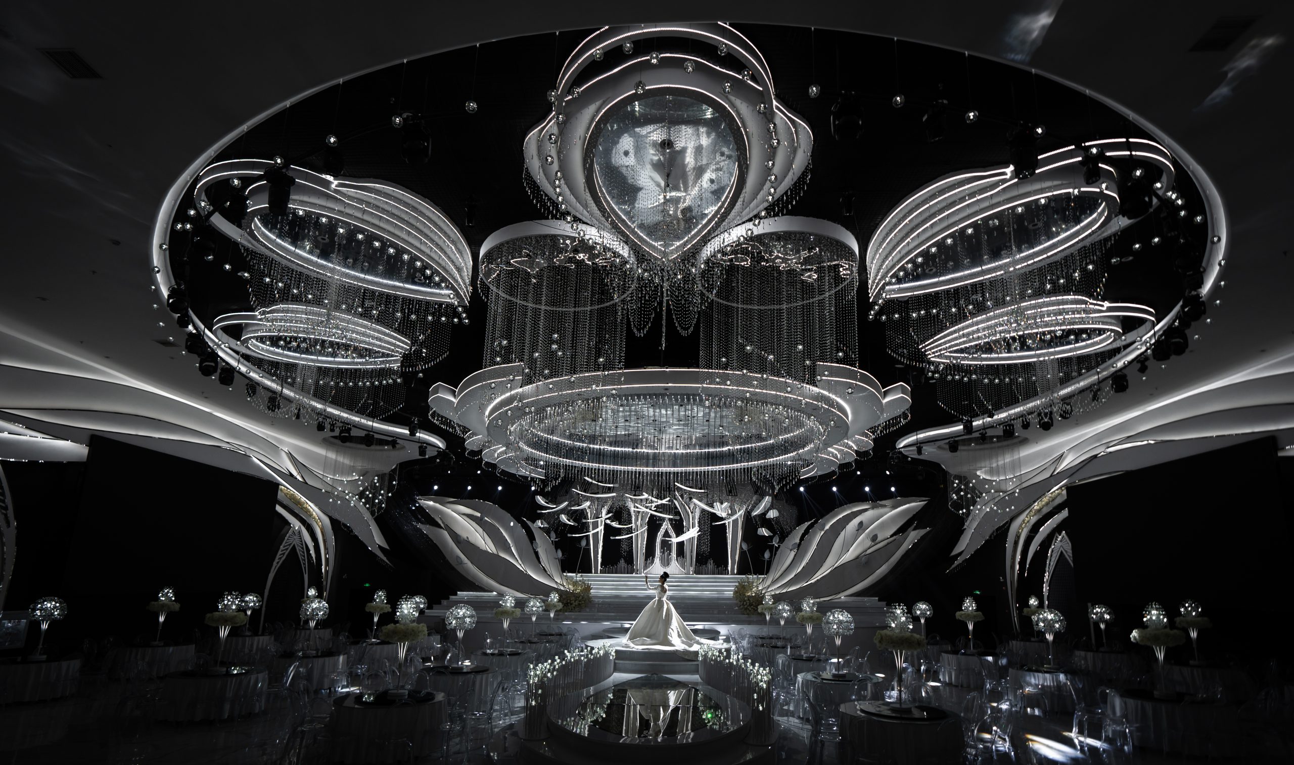 东肆设计天使之翼婚礼堂灯光氛围实景图，展示星空灯光、舞台背景、顶部水晶装置和主宴会厅空间效果